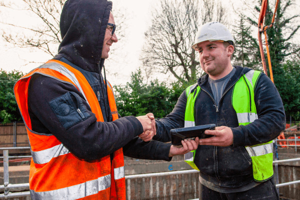 A Rapid Readymix operative shaking hands with a concrete delivery customer